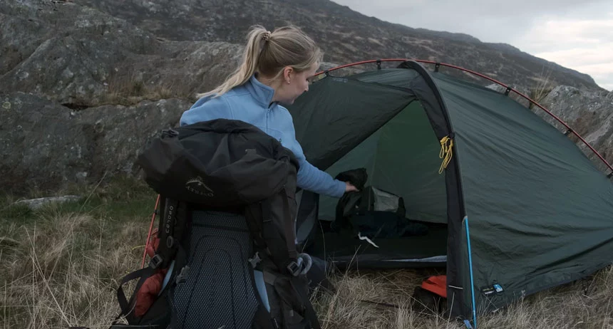 Woman preparing a tent and camping gear